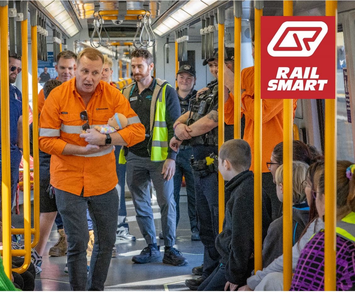 A Community Education Coordinator giving a thumbs up to a group of students on board a train