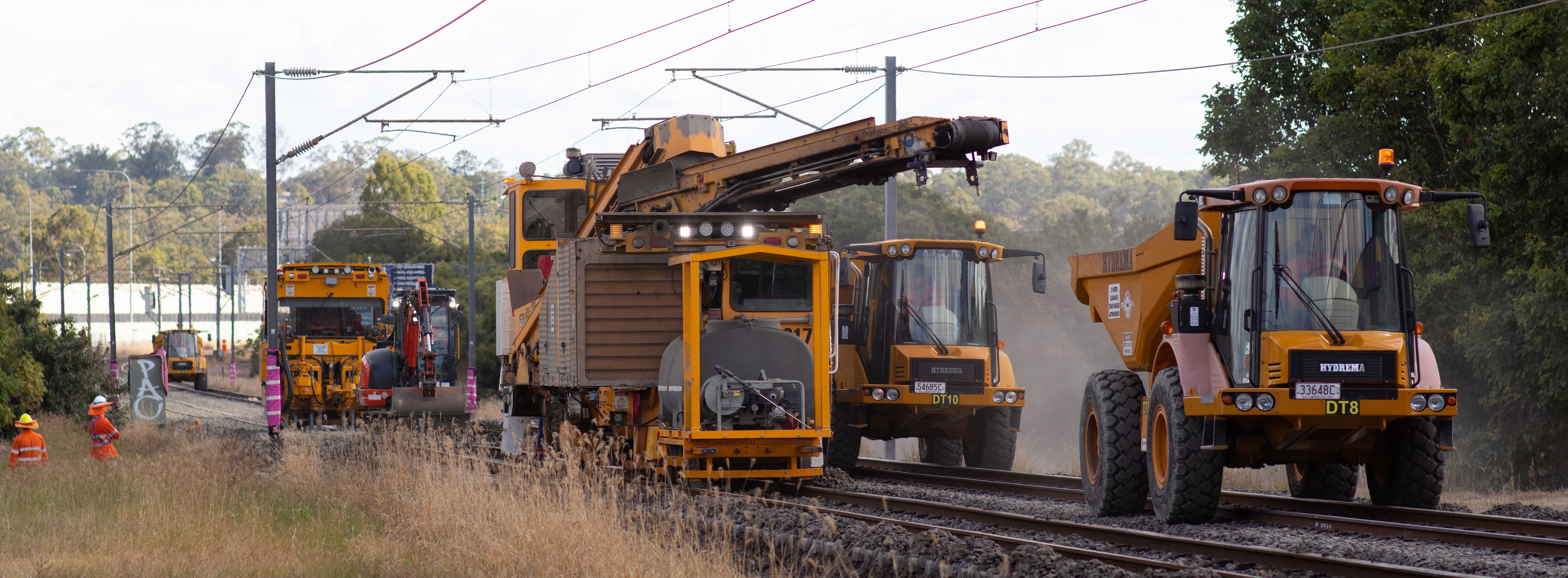 Image of construction workers and trucks carrying out maintenance on the rail line