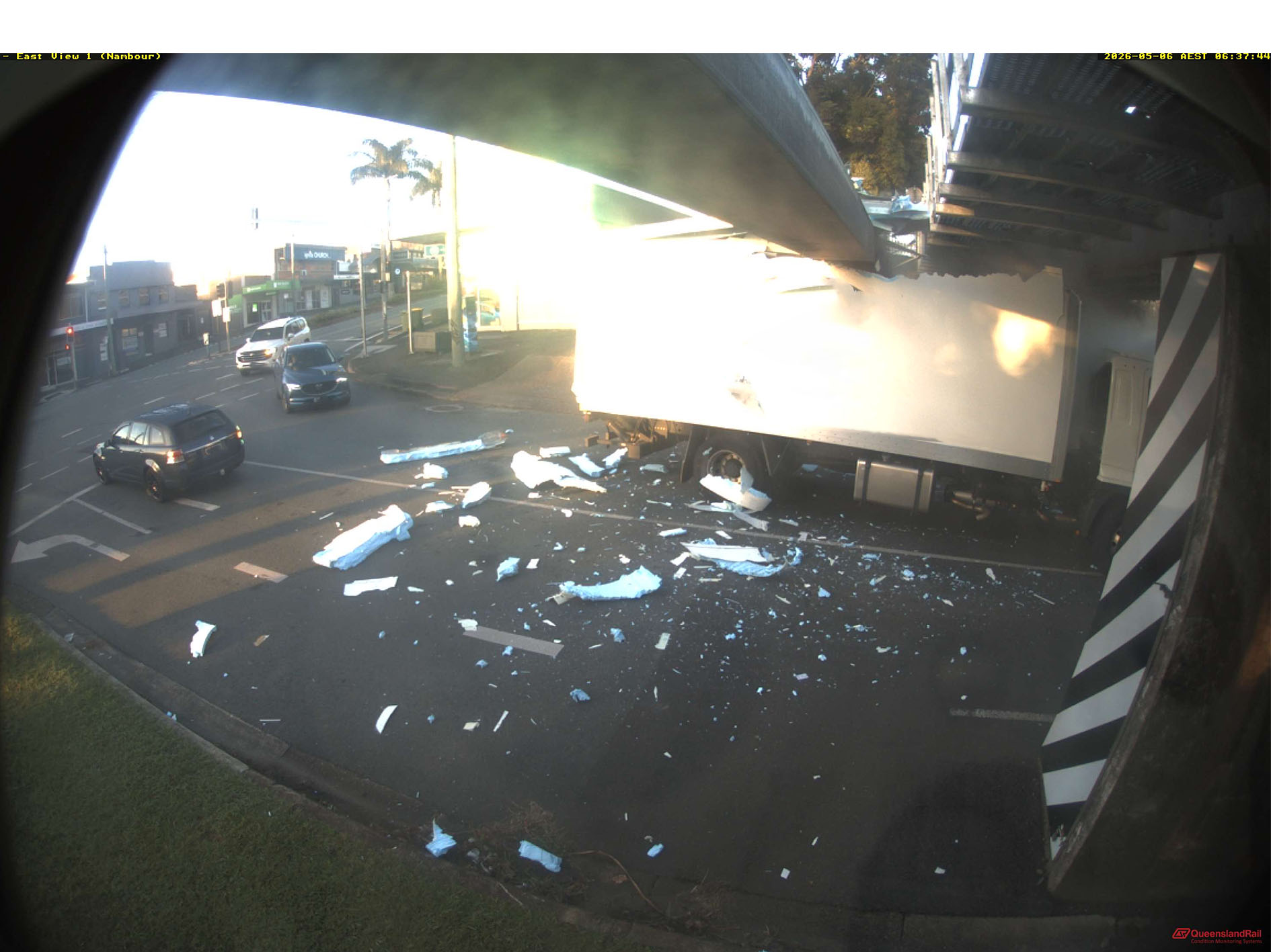 Large truck smashing under a rail bridge