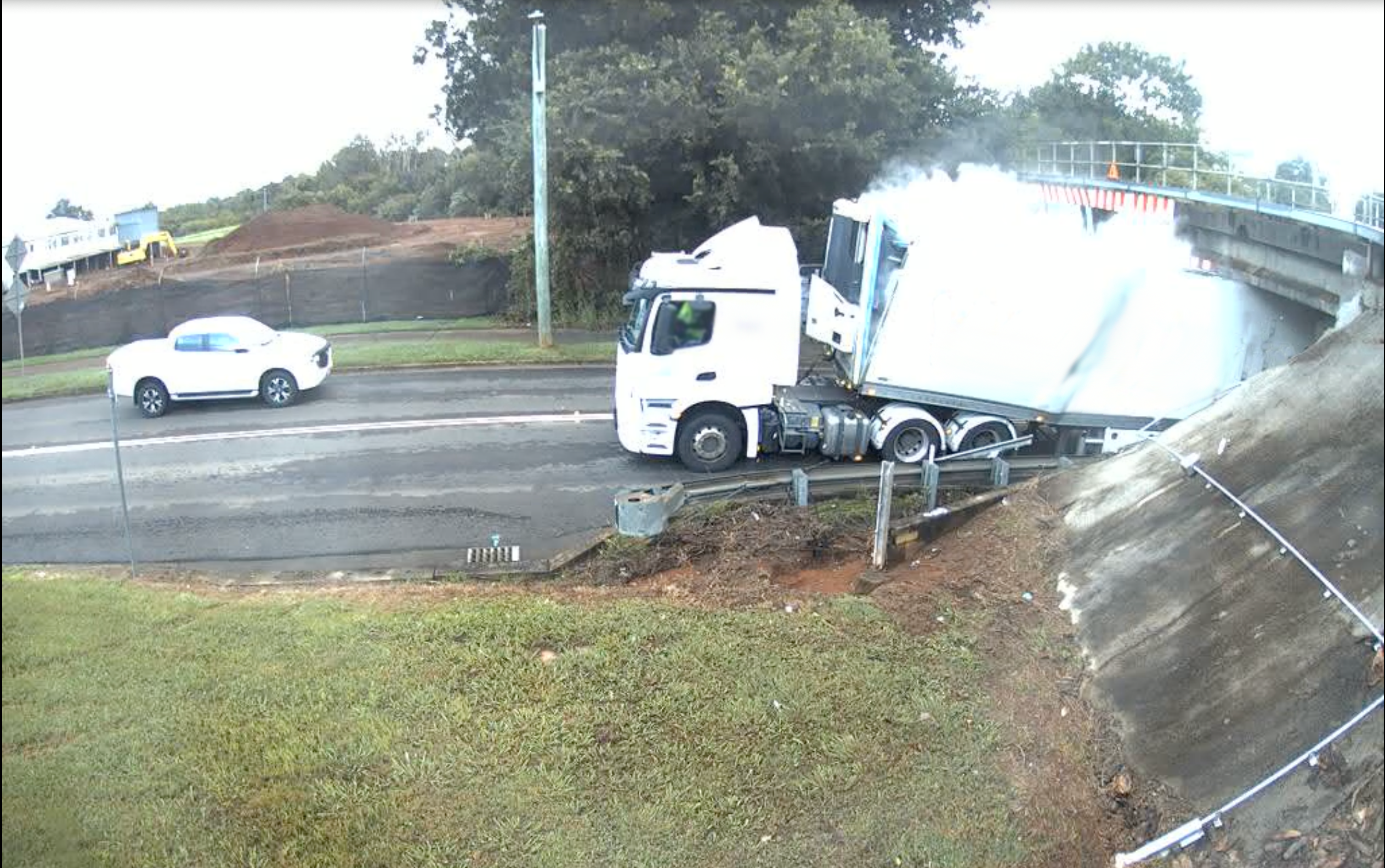 Large truck smashing under a rail bridge
