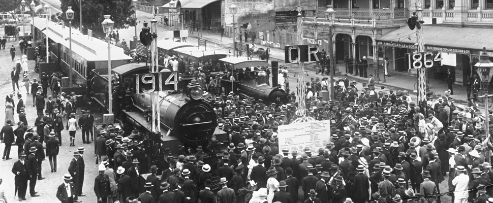 A photograph shows two steam locomotives – one built in 1865, and the other a brand new C18 class locomotive,full image description is available below. 