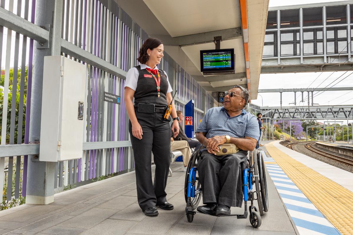 Station staff with customer on a train platform